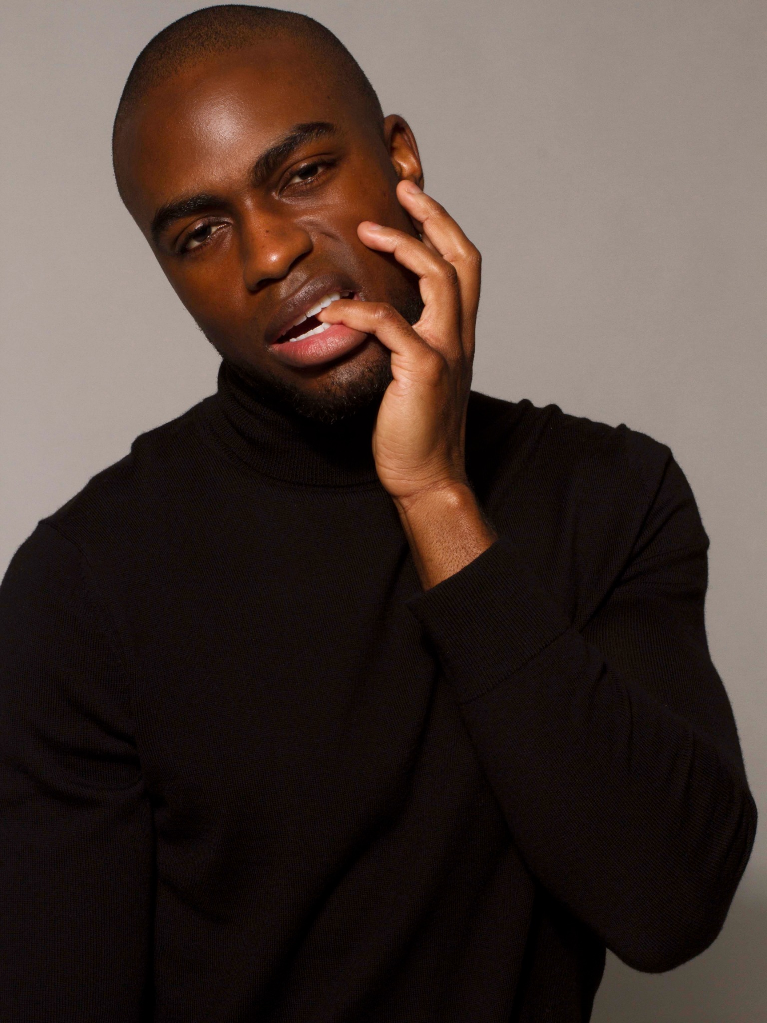 CJ Henry, founder of Red Ground Hair, wearing a black turtleneck