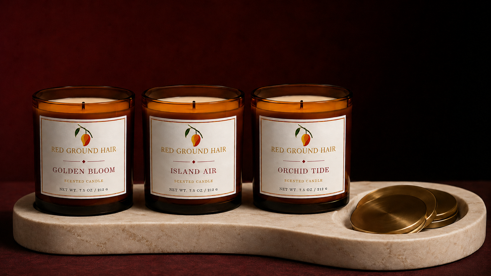 The three lit Red Ground Hair founding candles arranged together on an ivory plinth